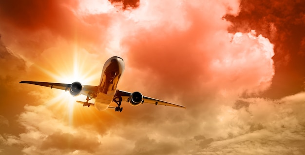 Plane goes on takeoff at sunset on cloudy sky background