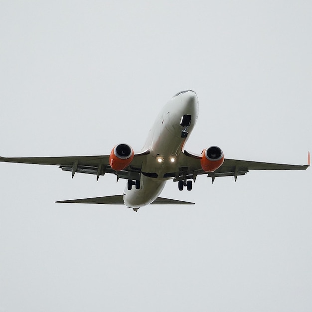 a plane is flying in the sky with the landing gear down