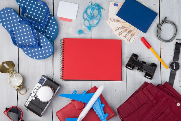 Plane passport money camera compass note pad binoculars jeans watch flip flops wallet