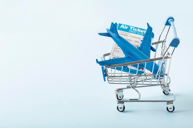 Plane in a shopping trolley Season travel concept background toned image