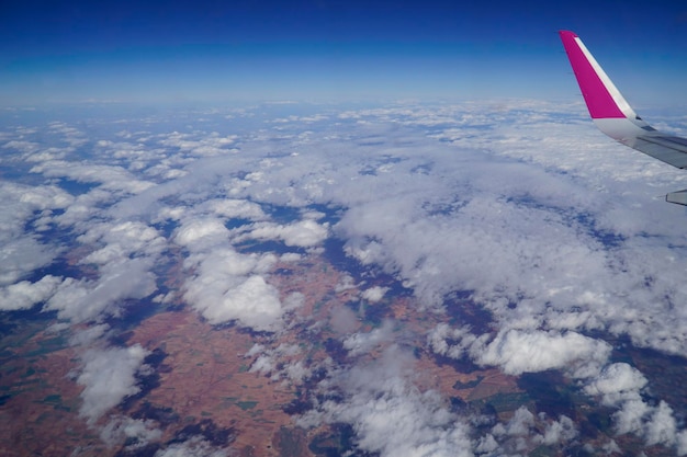 Plane wing and clouds while flying