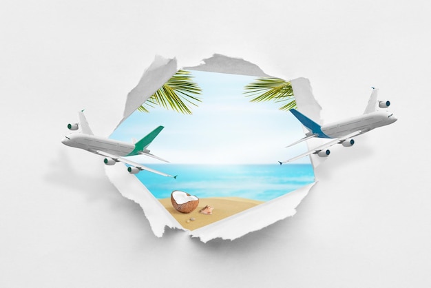 Planes break through paper and make a hole through which a tropical dream beach Summer travel concept