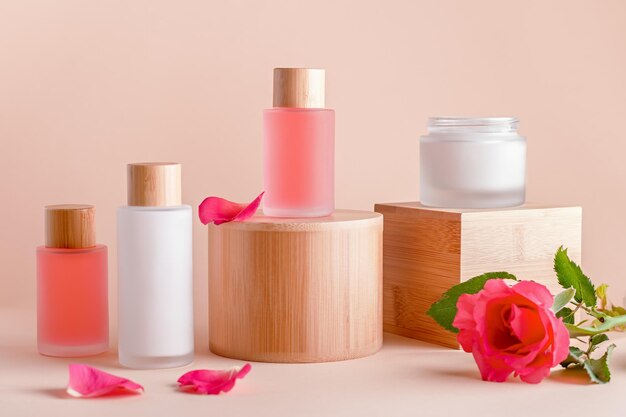 Plant based rose cosmetics on stands or risers with rose flower still life Concept of natural organic beauty products for skin care and beauty treatment