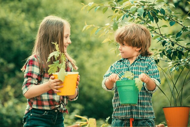 Planting flowers in pot pretty cute kids working and playing in beautiful garden little kids work in