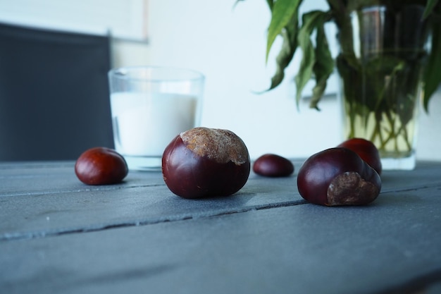 Plants and flowers of Jerusalem artichoke in a vase Chestnut fruits on the table Table and chairs on the balcony or terrace End of season at the hotel The table is painted silver