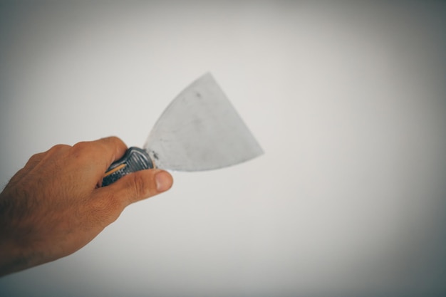 Plastering wall with puttyknife close up image