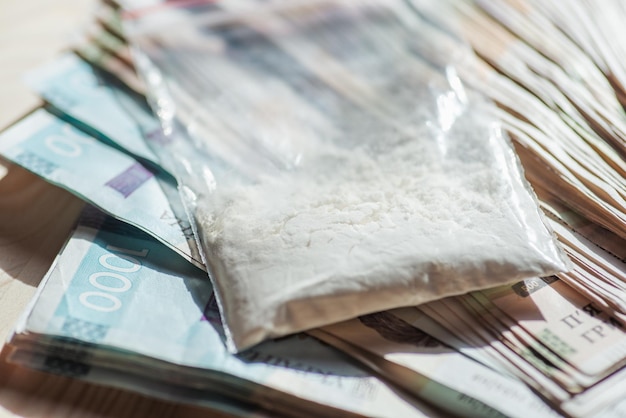 Plastic bag with drugs on ukrainian hryvnia money Drug dealership concept