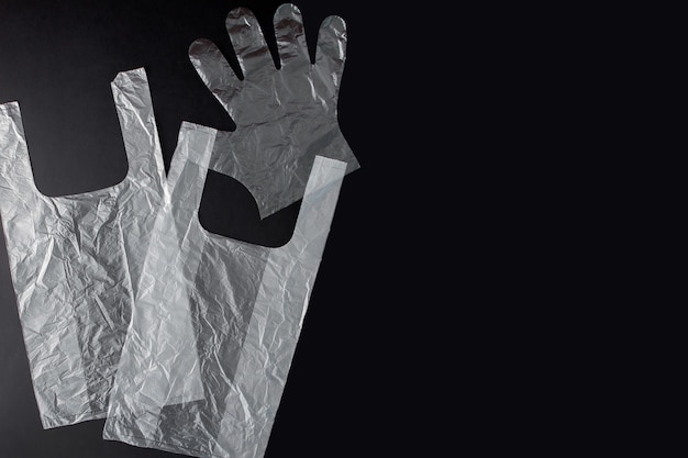 Plastic bag with handles, gloves, on a black