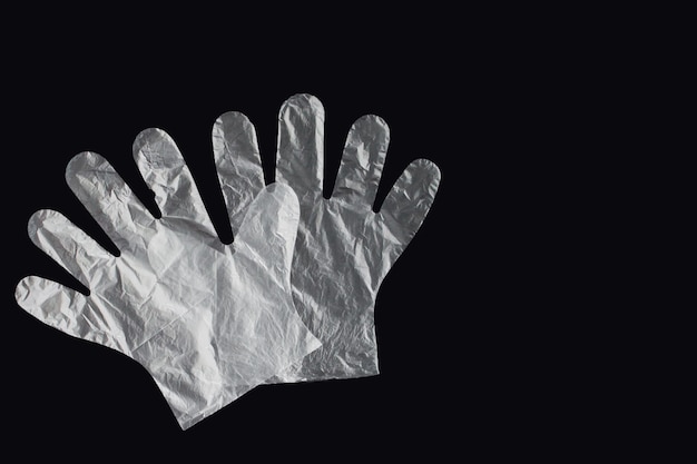 Plastic bag with handles, gloves, on a black