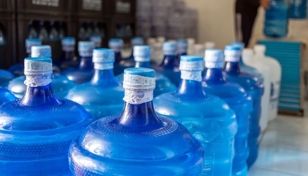 Plastic big bottles blue gallons of purified drinking water inside the production