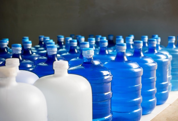 plastic big bottles or white and blue gallons of purified drinking water inside the production