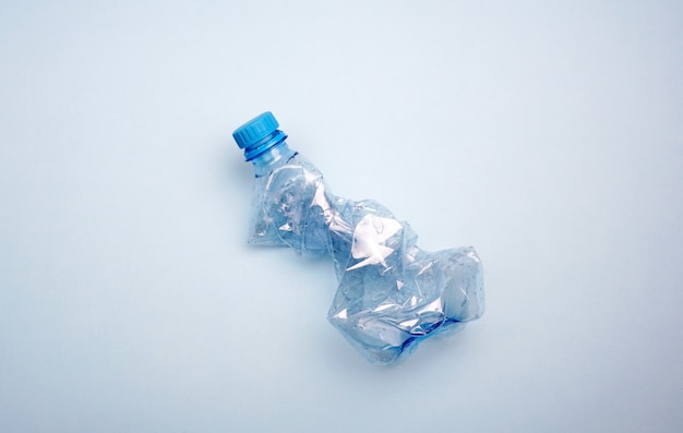 Plastic bottle on blue background. Minimal concept of ocean pollution