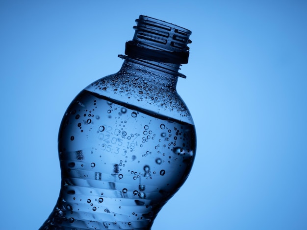 Plastic bottle and a glass with ice