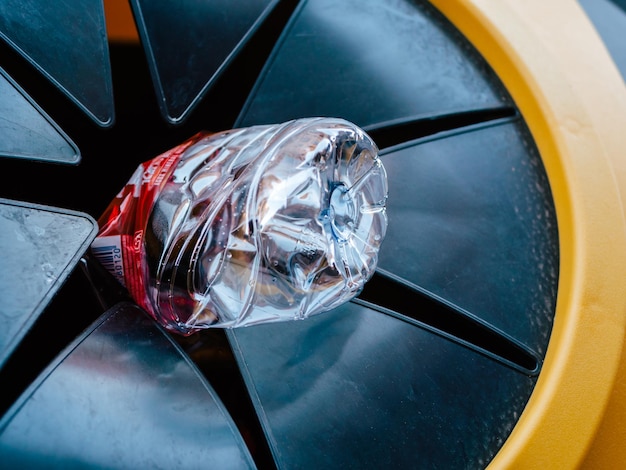 Plastic bottle goes into a yellow stationary rubbish bin Right way of rubbish sorting