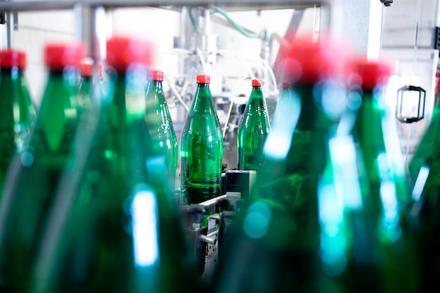 Plastic bottles on conveyor belt being filled with drinking water