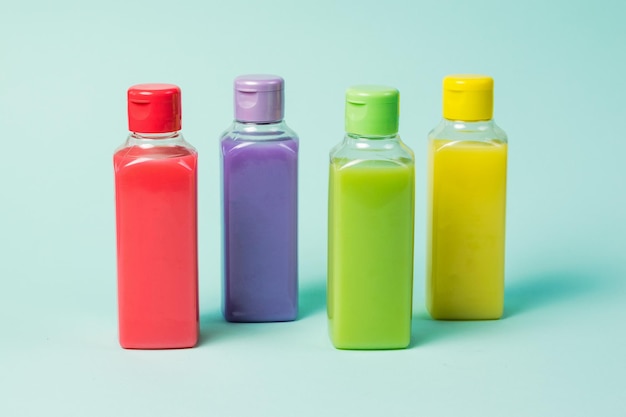 Plastic bottles of four colors on a blue background