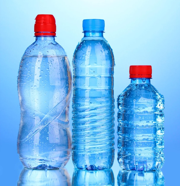 Plastic bottles of water on blue background