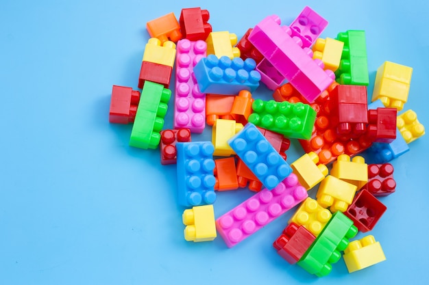 Plastic building blocks on blue wall.