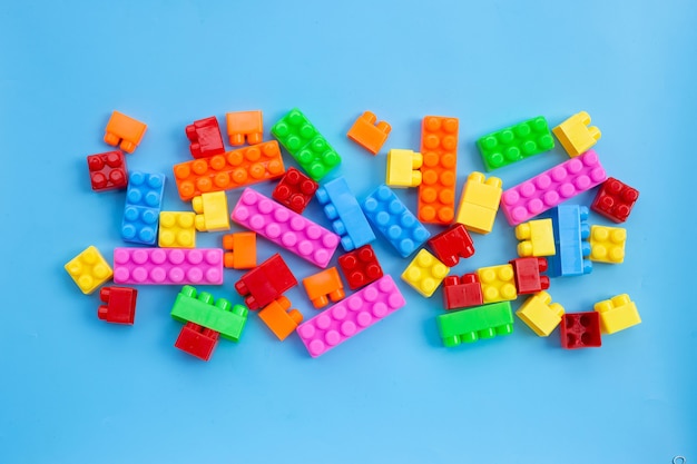 Plastic building blocks on blue wall.