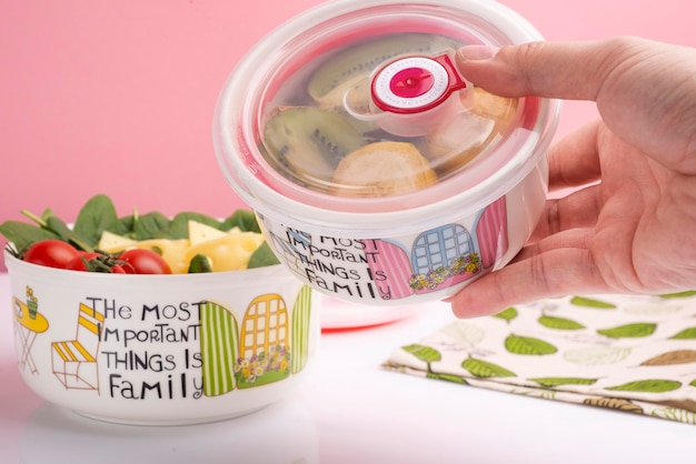 plastic containers in hand with fruits and vegetables