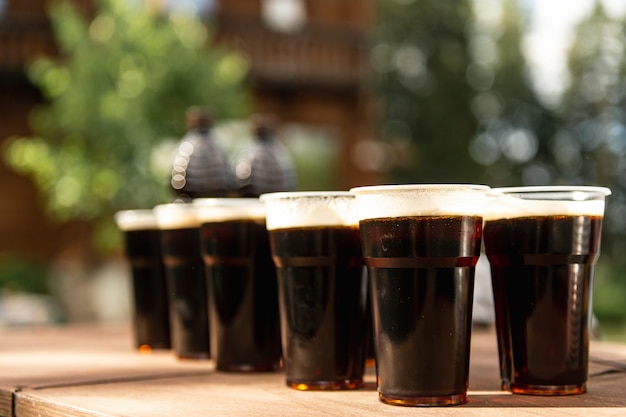 Plastic cups with draft beer on the table for group outdoors