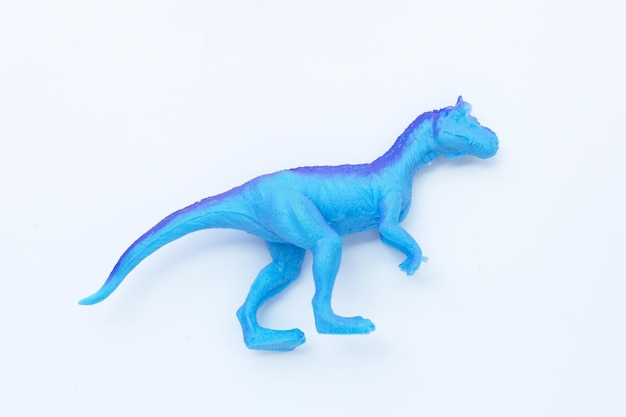 Plastic dinosaur toy on white background Top view