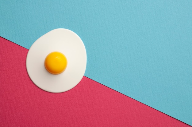 Plastic egg on blue and pink surface