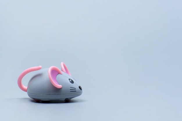 Plastic mouse toy on a gray surface