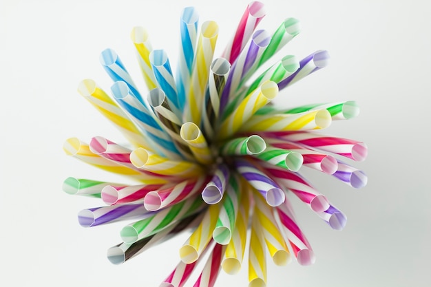 Plastic multi-colored straw tubules for drinking on a white background.  