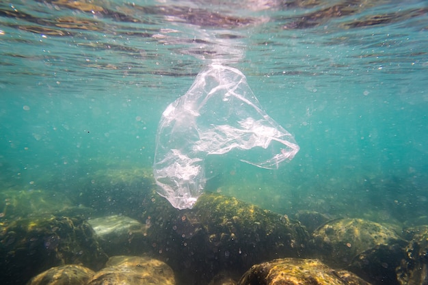 Plastic pollution a discarded plastic rubbish bag floats on a tropical coral reef presenting a hazard to marine life