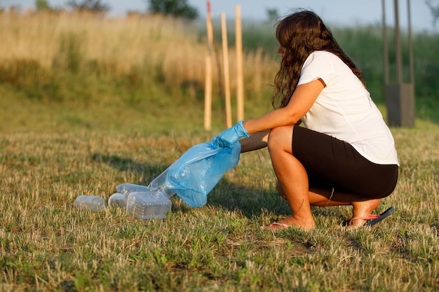 Plastic pollution in the environmental problem of the world A hand in a blue glove puts garbage in a plastic bag Removal and cleaning of garbage from contaminated territories