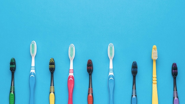 Plastic toothbrushes on a light pink background Flat lay