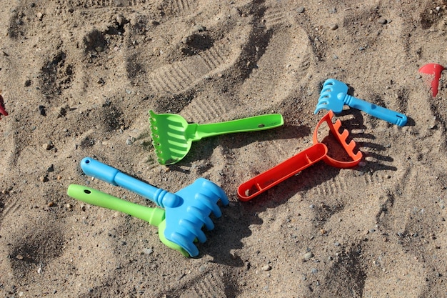 Plastic toy rake in the sandbox