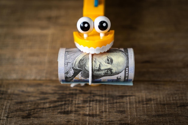 Plastic toy teeth with a dollar banknote.