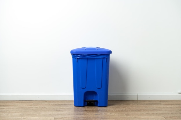 Plastic waste bin with a lid in the room