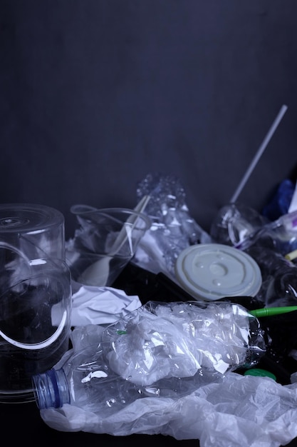 Plastic waste, plastic garbage pollution on a dark background. The concept of waste disposal, ecolog