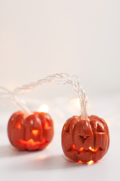 Plasticine pumpkins on a blurry background of a burning garland