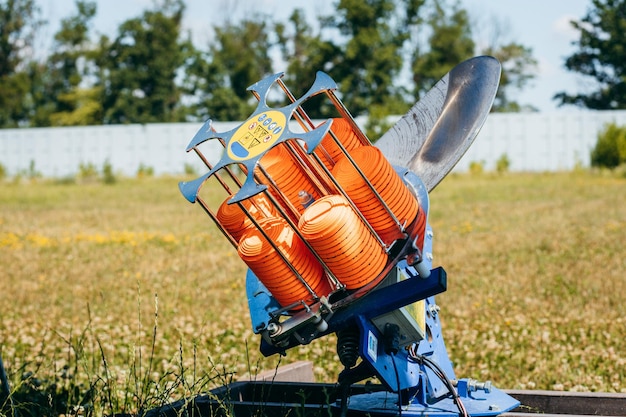 Plat machine with orange shooting plate for shootingground training on field with grass