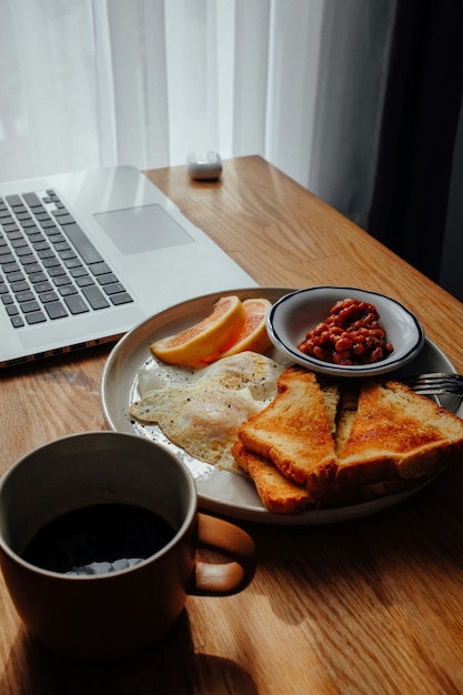 a plate of breakfast food and a cup of coffee on a table