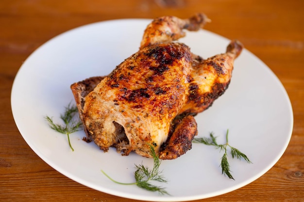 A plate of chicken on a table with dill on it