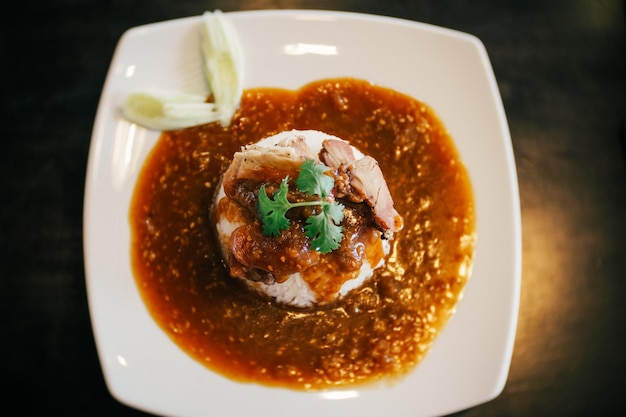 A plate of Chinese BBQ pork on rice with gravy on top