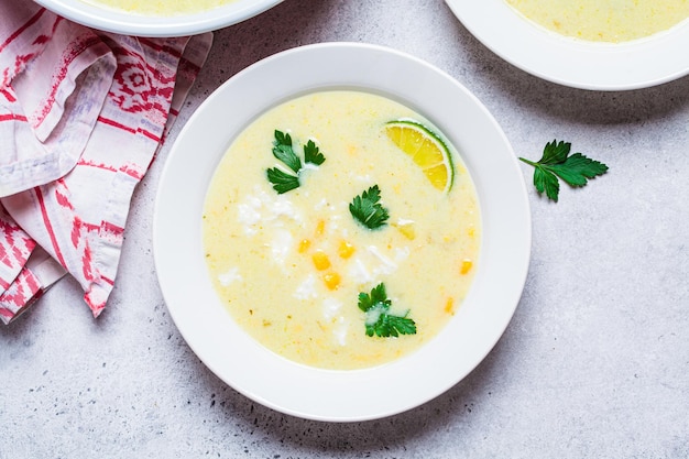 Plate of corn soup with cheese and herbs