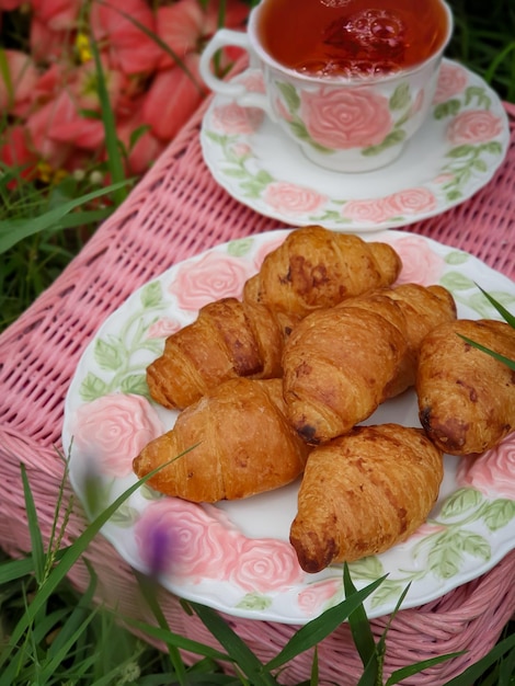 Photo a plate of croissants with a pink rose design on it.