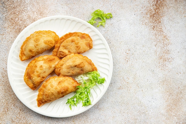 Photo a plate of empanadas with a leafy green vegetable on it