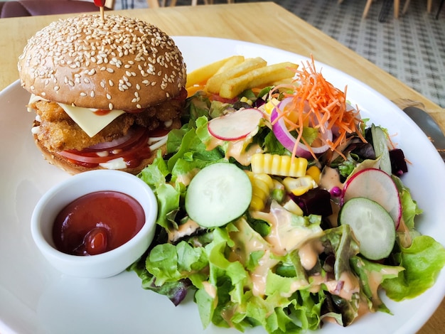 A plate of food with a burger and salad on it