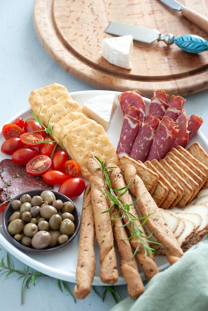 A plate of food with a cracker and olives