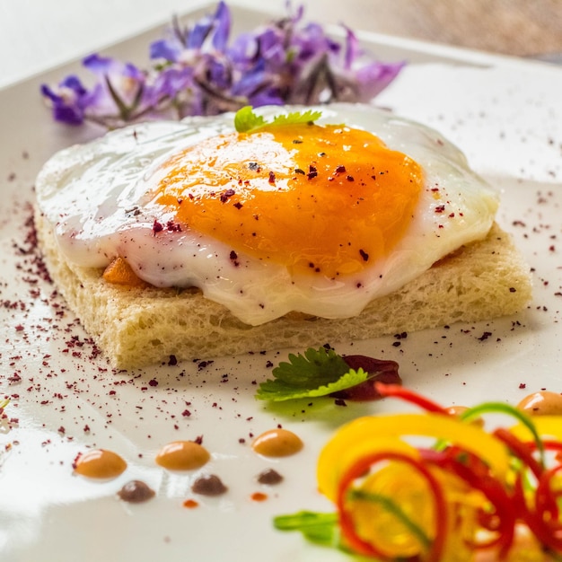 A plate of food with an egg on it and some other food on it.