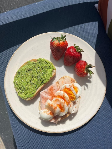 Photo a plate of food with eggs eggs and a sandwich