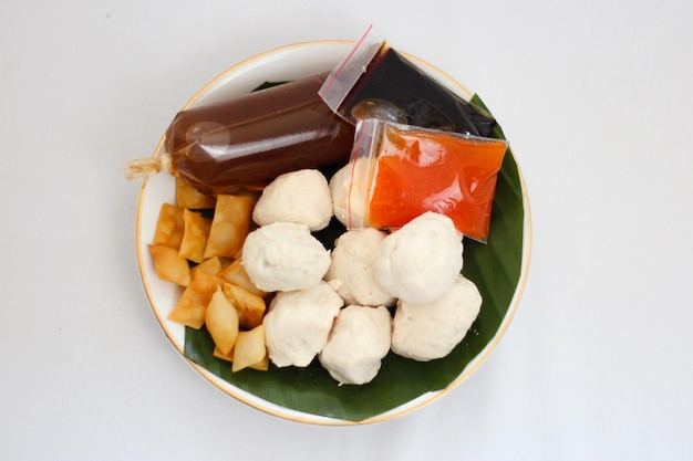 A plate of food with meatball fish and a red sauce