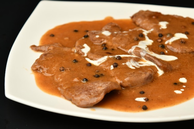 A plate of food with a piece of chicken and black beans